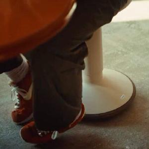 Sneaker naast een oranje kruk