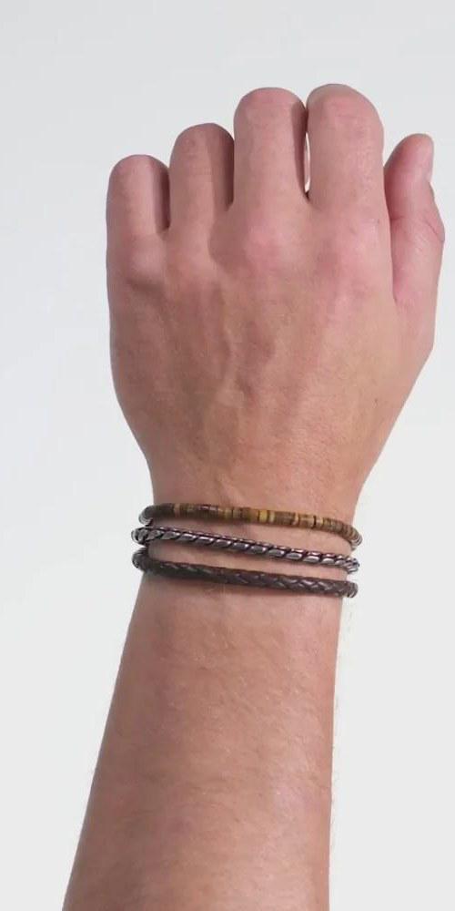 Foto van een pols met drie armbanden