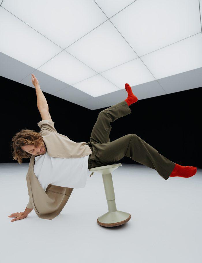 Model dat van een zadelkruk valt in een witte studio