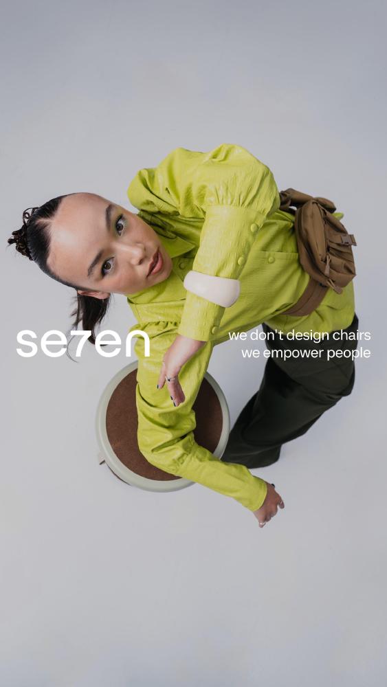 Se7en-campagneposter met een model in een limoengroene blouse op een zadelkruk