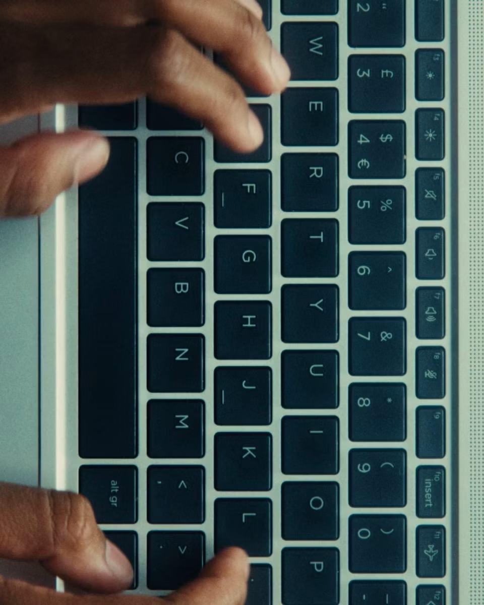 Handen die typen op het toetsenbord van een laptop
